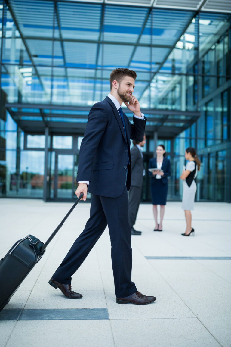 businessman holding suitcase talking mobile phone